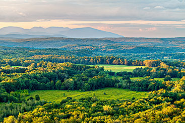 A beautiful forested landscape with the silhouette of some mountains in the background. What to Give A beautiful forested landscape with the silhouette of some mountains in the background. What to Give